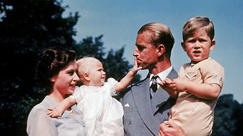 The first color photograph of Princess ANNE, taken in 1951, in the arms of her mother Queen ELIZABETH II while her father, Philip MOUNTBATTEN, holds her brother Prince CHARLES. The family lives at Clarence House, in London.