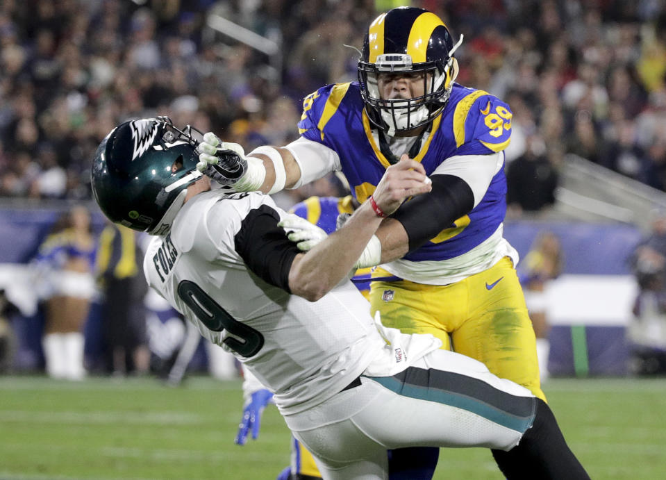 FILE - In this Dec. 16, 2018, file photo, Los Angeles Rams defensive end Aaron Donald hits Philadelphia Eagles quarterback Nick Foles after Foles threw the ball away during the first half in an NFL football game in Los Angeles. The Rams know they've got to pressure Tom Brady early and often to have a chance in the Super Bowl, and they've been assembling the tools for this job all year long. They signed Ndamukong Suh to a big free-agent deal, wrote a record-breaking contract for Aaron Donald and acquired edge rusher Dante Fowler from Jacksonville down the stretch. (AP Photo/Jae C. Hong, File)