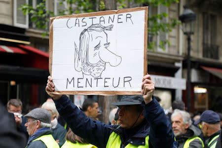 A demonstrator holds up a placard which reads "Castaner (French Interior Minister Christophe Castaner) liar" during a demonstration of yellow vests in Paris, France, May 4, 2019. REUTERS/Charles Platiau