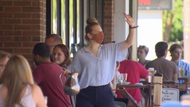 Staff at restaurants and pubs are free to remove masks for the first time in nearly a year, if employers allow it.  (Sam Martin/CBC - image credit)