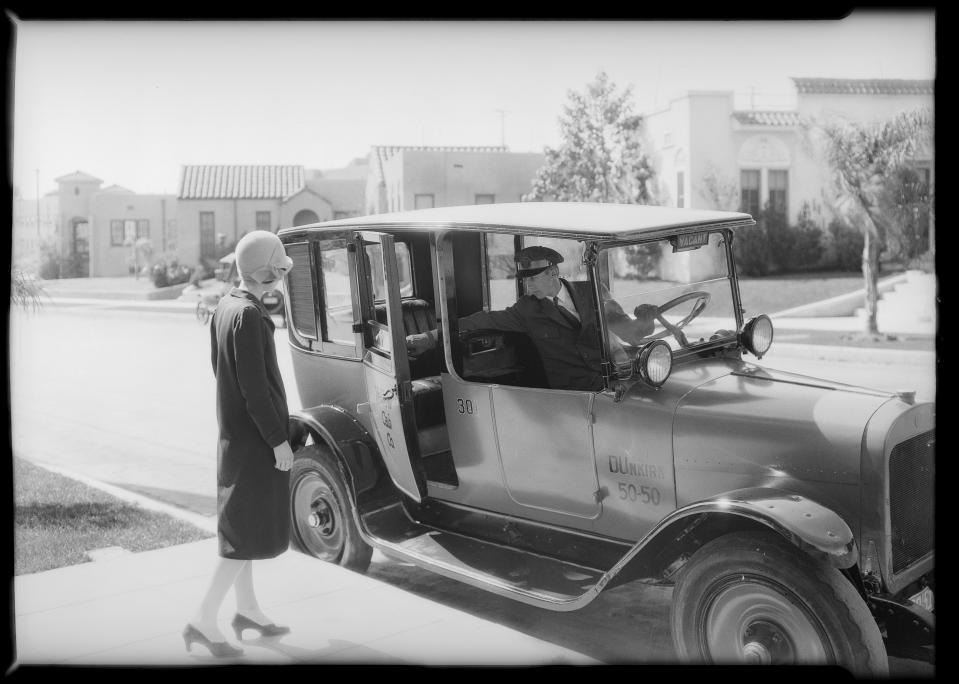 woman gets into cab 1920s car