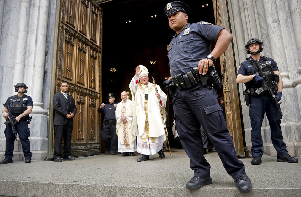 Cardinal Dolan surrounded by police