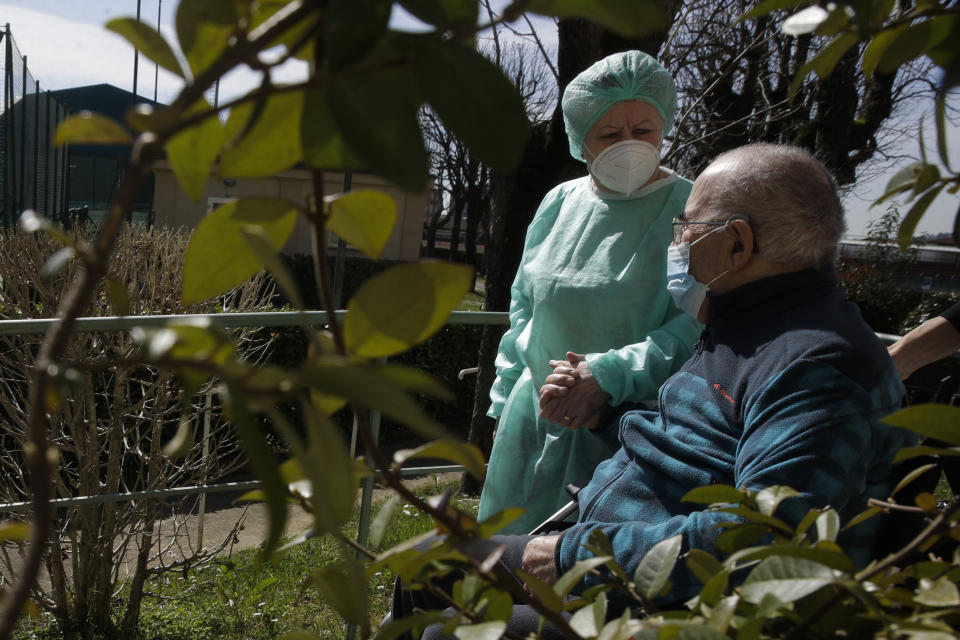 Palmiro Tami, 82, holds hand with his wife Franca Persico as the have a walk through the garden of the Fondazione Martino Zanchi nursing home, after receiving the second shot of Moderna COVID-19 Vaccine, in Alzano Lombardo, northern Italy, Monday, March 22, 2021. Italy's nursing homes have been declared an initial success in an otherwise lagging vaccine campaign. At a nursing home near Bergamo, one 82-year-old resident received his second jab, and a surprise visit from his 77-year-old wife. Their last hug had been through plastic on his birthday, in February. (AP Photo/Luca Bruno)