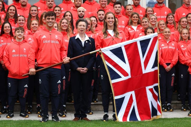 Anne stands between Team GB Flagbearers Helen Glover and Tom Daley, and other team members in their Team GB sports tracksuits ahead of Paris 2024 Olympics