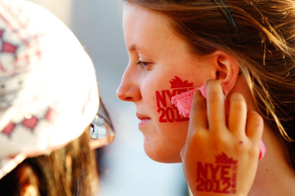 SYDNEY, AUSTRALIA - DECEMBER 31: A woman receives a New Years themed sticker prior to New Years Eve celebrations on Sydney Harbour on December 31, 2012 in Sydney, Australia. (Photo by Brendon Thorne/Getty Images)