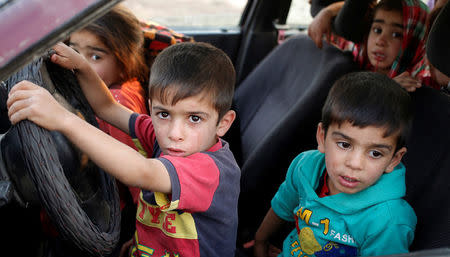 Internally displaced children sit in a car near Hassan Sham, east of Mosul, Iraq October 25, 2016. REUTERS/Goran Tomasevic