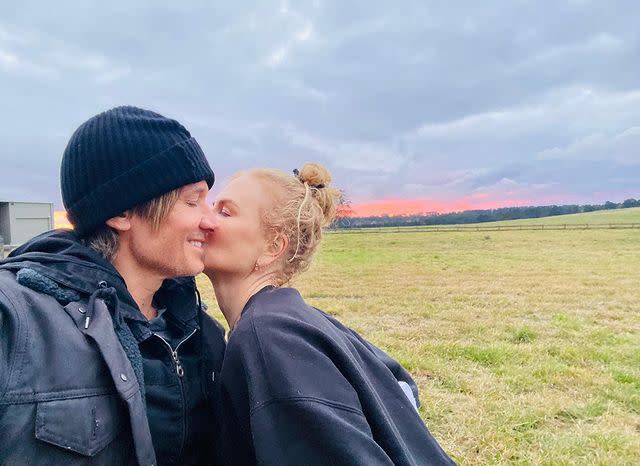 Nicole Kidman kisses Keith Urban on the cheek in a grassy field. Photo: Instagram/nicolekidman.