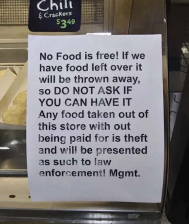 A sign in a store states that any leftover food will be thrown away and not given for free. Taking food without payment is theft and will be reported to law enforcement