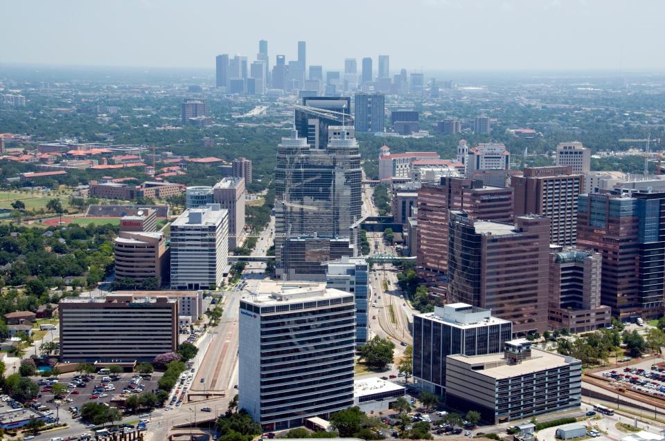 A partial skyline of Texas Medical Center's 59 institutions, including Memorial Hermann Hospital, looms with downtown Houston in the distance.