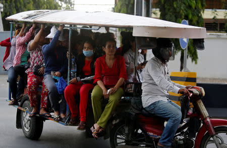 Garment workers travel back home as they leave a factory after work, on the outskirts of Phnom Penh, Cambodia, October 16, 2018. Picture taken October 16, 2018. REUTERS/Samrang Pring