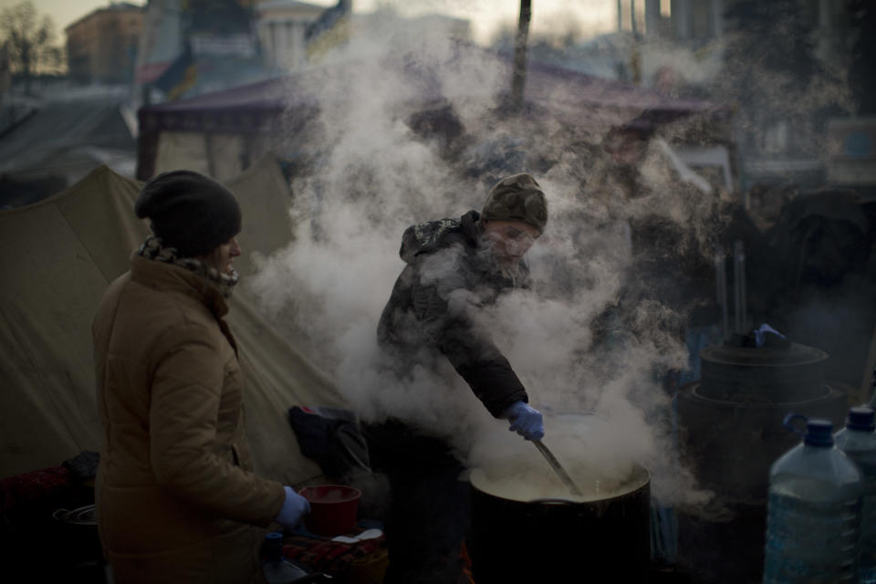 An opposition supporter makes soup for his comrades in Kiev's Independence Square, the epicenter of the country's current unrest, Ukraine, Wednesday, Feb. 5, 2014. The mayor of a western city warned that his police would fight any troops sent in by the president. The governor of an eastern region posted an image of an opposition lawmaker beaten bloody, saying he couldn't contain his laughter. Two months into Ukraine's anti-government protests, the two sides are only moving further apart. (AP Photo/Emilio Morenatti)