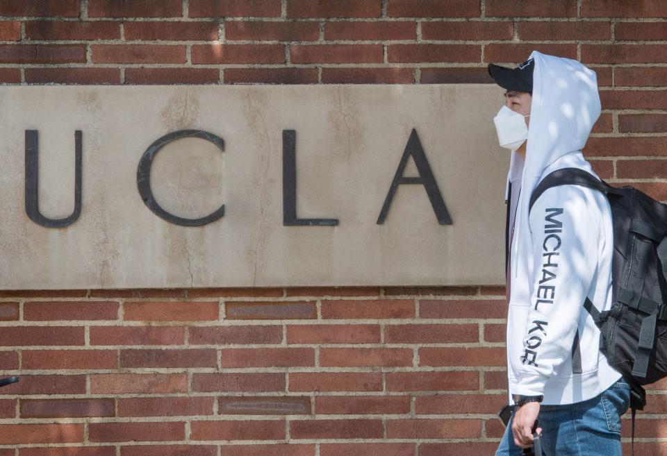 A student wears a face mask to protect against the COVID-19 (Coronavirus) as he leaves the campus of the UCLA college in Westwood, California on March 6, 2020. - Three UCLA students are currently being tested for the COVID-19 (coronavirus) by the LA Departement of Public Health, according to the UCLA Chancellor Gene Block. (Photo by Mark RALSTON / AFP) (Photo by MARK RALSTON/AFP via Getty Images)