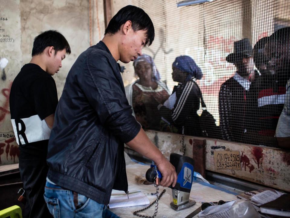 A man from China tests the purity of cobalt he's buying at the Musompo market