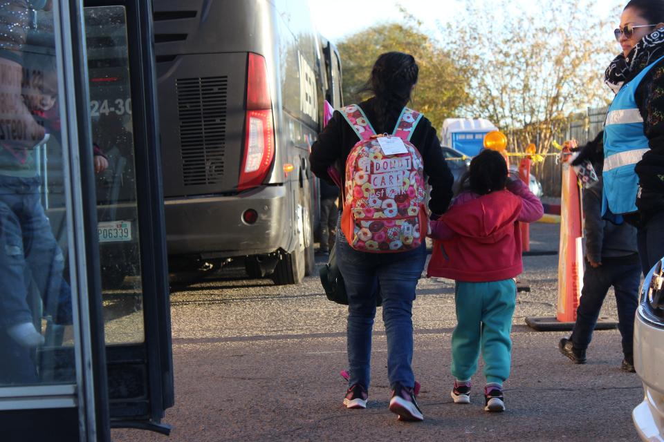 Migrants board a bus behind the Pimeria Alta Historical Society Museum in Nogales after being dropped off by Border Patrol on Thursday, Dec. 14, 2023.