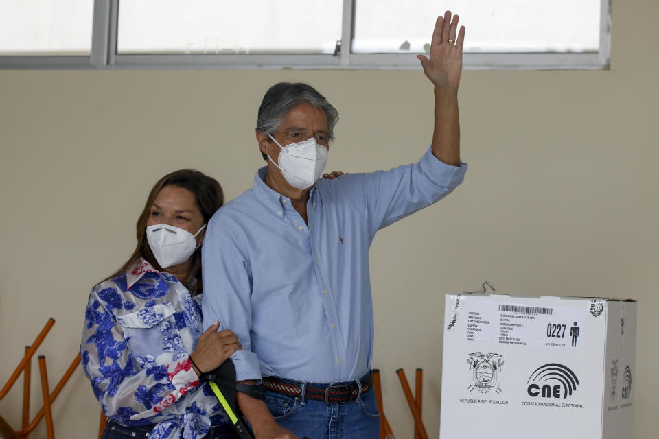 Guillermo Lasso, candidato presidencial del partido Creando Oportunidades o CREO, saluda después de votar acompañado por su esposa, María de Lourdes Alcívar, durante una segunda vuelta de las elecciones presidenciales en Guayaquil, Ecuador, el domingo 11 de abril de 2021. (Foto AP/Angel Dejesus)