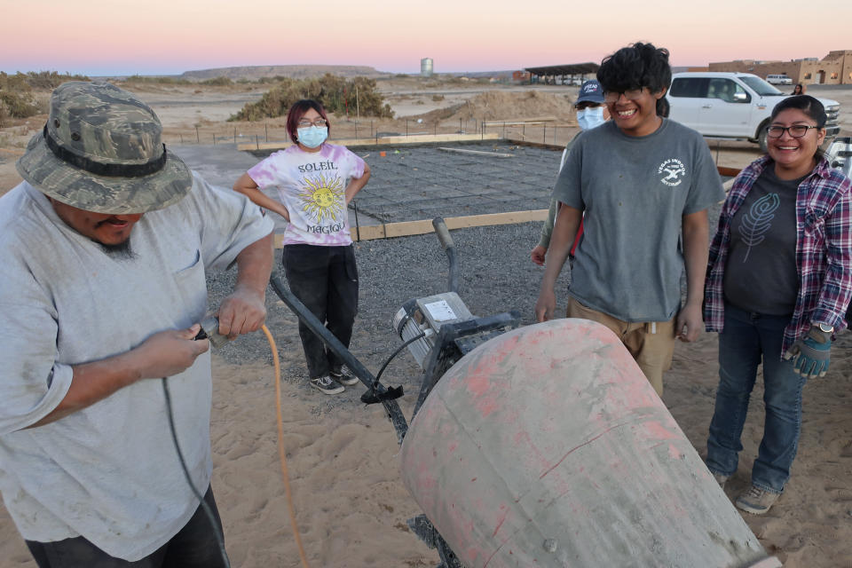 Francisco Mata, left, Kira Nevayaktewa, Quintin Nahsonhoya and Felicia Mata help lay a concrete foundation for a skate ramp on Nov. 6, 2021, in the Village of Tewa on the Hopi reservation in northeastern Arizona. A handful of Hopi youth, including Nevayaktewa and Nahsonhoya, worked together to create the skate spot that opened this spring. (AP Photo/Felicia Fonseca)
