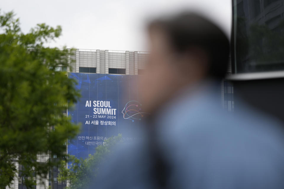 A man on a bicycle passes by a huge banner for the upcoming AI Seoul Summit in Seoul, South Korea, Monday, May 20, 2024. South Korea is set to host a mini-summit this week on risks and regulation of artificial intelligence, following up on an inaugural AI safety meeting in Britain last year that drew a diverse crowd of tech luminaries, researchers and officials. (AP Photo/Lee Jin-man)