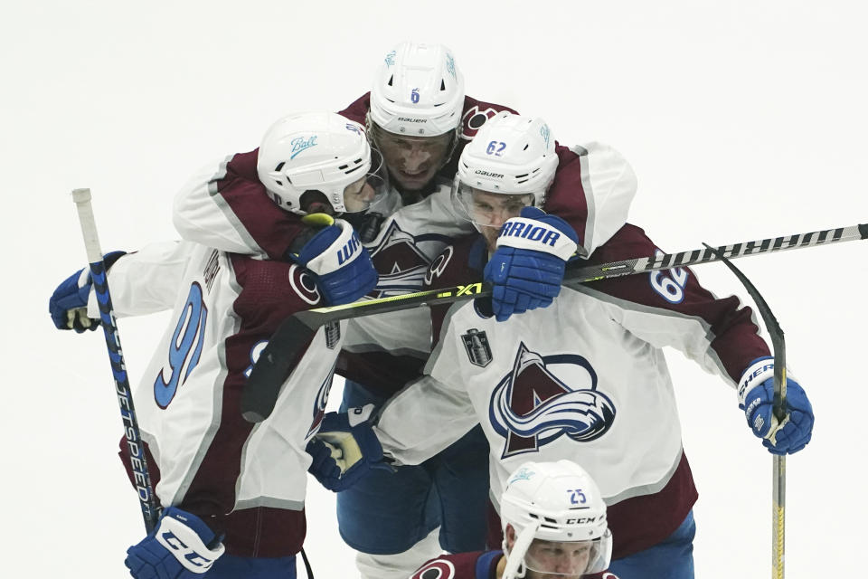 Colorado Avalanche defenseman Erik Johnson, center, and left wing Artturi Lehkonen, right, congratulate center Nazem Kadri, left, after his overtime goal on Tampa Bay Lightning goaltender Andrei Vasilevskiy in Game 4 of the NHL hockey Stanley Cup Finals on Wednesday, June 22, 2022, in Tampa, Fla. (AP Photo/John Bazemore)