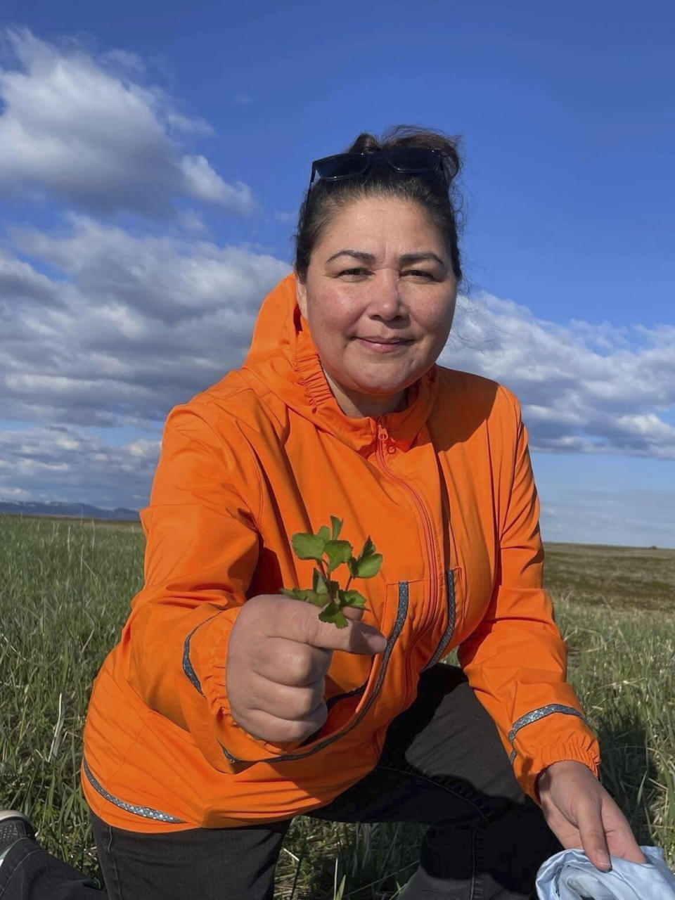 This undated photo shows Alice Bioff wearing an Atmik, a water-proof garment she makes that resembles the traditional Alaska Native garment called a kuspuk in Nome, Alaska. The garment was inspired by a tourist she met in 2016 when she was a tour guide, and she hopes the $600 million expansion of the Port of Nome will translate into support of Nome stores and Indigenous artists. (Alice Bioff via AP)