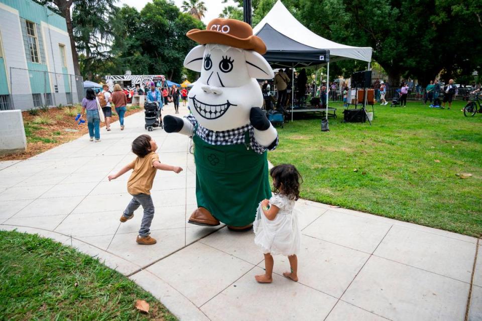 Clover Sonoma’s mascot, Clo the Cow, dances with kids during the 50th anniversary celebration of the Sacramento Natural Foods Co-op at Winn Park on Saturday.