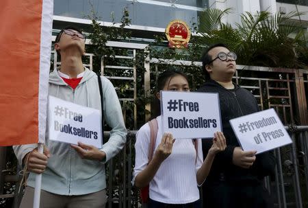 Members of student group Scholarism hold up placards during a protest about the disappearances of booksellers outside China's liaison office in Hong Kong, China January 6, 2016. REUTERS/Bobby Yip