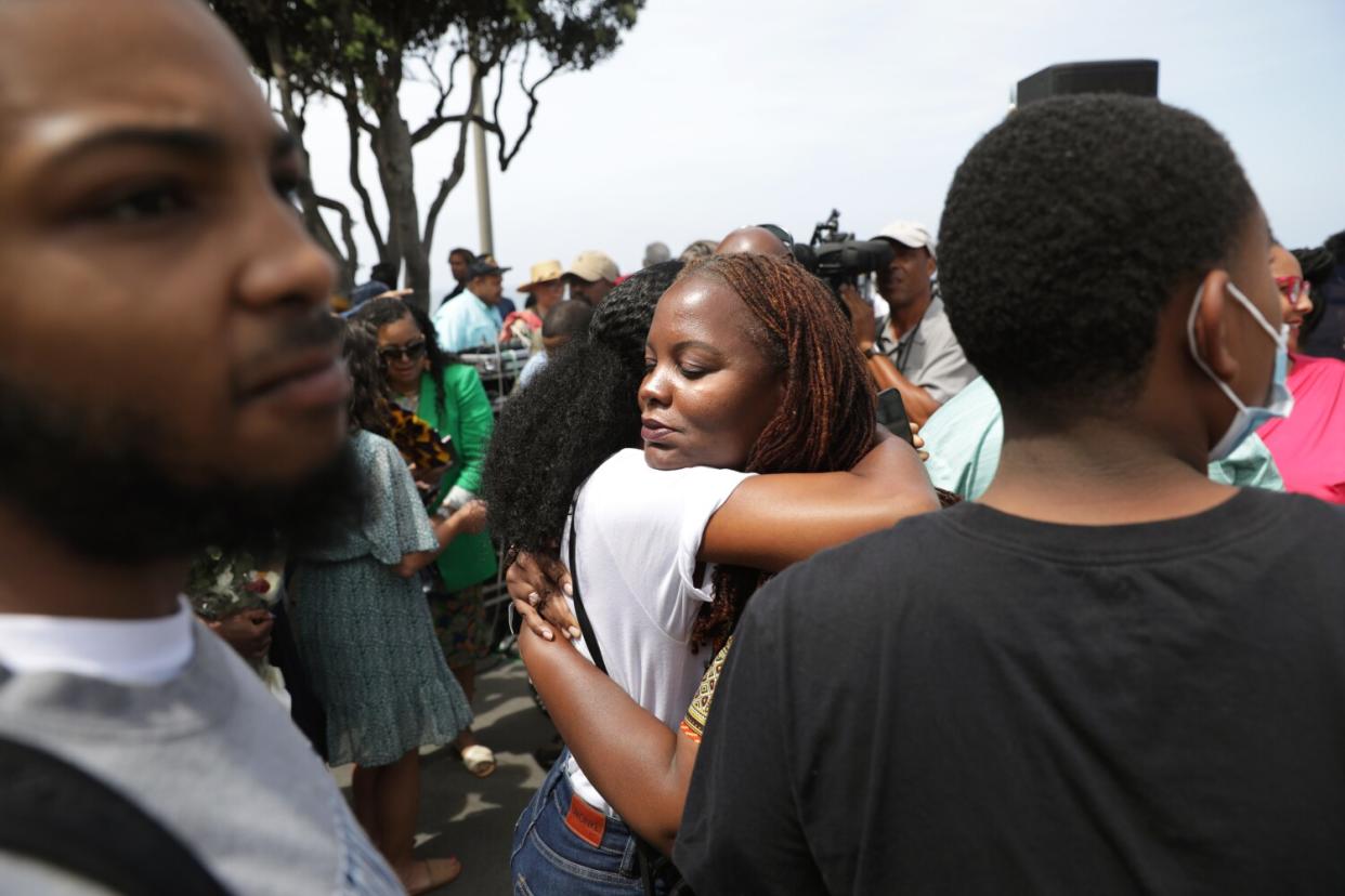 Milan Whippa Wiley and Kavon Ward, center right, embrace after the ceremony at Bruce's Beach on Wednesday