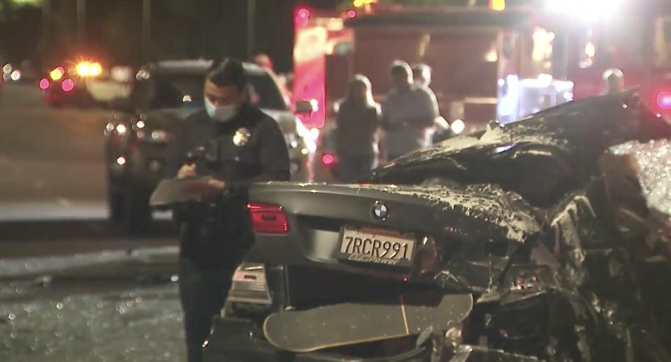 The smashed BMW at the LA scene with a police officer seen in the background.