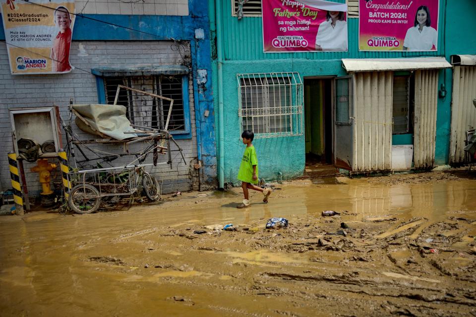 A child walks along a muddied road after it was flooded by Typhoon Gaemi (Getty Images)