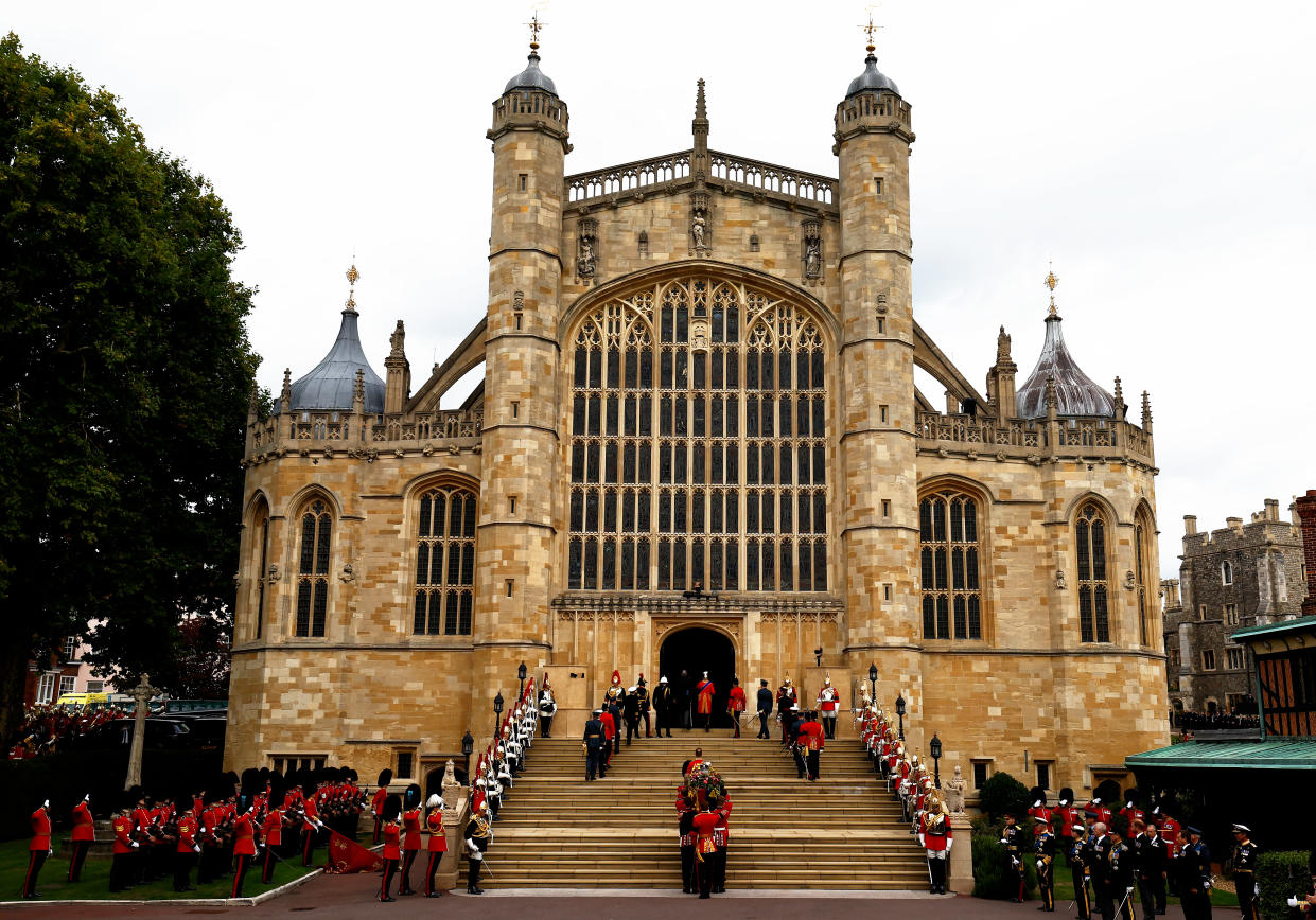 WINDSOR, ENGLAND - SEPTEMBER 19: A general view of pall bearers from the first battalion Grenadier Guards as they carry the coffin of Queen Elizabeth II with the Imperial State Crown resting on top into St. George's Chapel on September 19, 2022 in Windsor, England. The committal service at St George's Chapel, Windsor Castle, took place following the state funeral at Westminster Abbey. A private burial in The King George VI Memorial Chapel followed. Queen Elizabeth II died at Balmoral Castle in Scotland on September 8, 2022, and is succeeded by her eldest son, King Charles III. (Photo by Jeff J Mitchell/Getty Images)