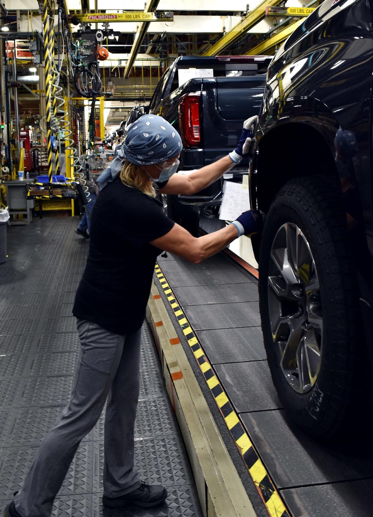 A worker wears a face mask while building GM’s full-size pickups at Fort Wayne Assembly plant in Indiana on Jan. 7, 2021.