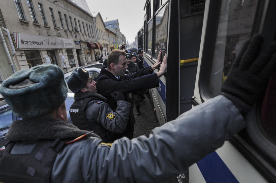 Opposition leader Alexei Navalny is searched by a police officer after being detained in Moscow, Saturday Oct. 27, 2012. Russian opposition leaders have been detained while protesting against torture which they believe was applied to their fellow activist. (AP Photo/Sergey Ponomarev)