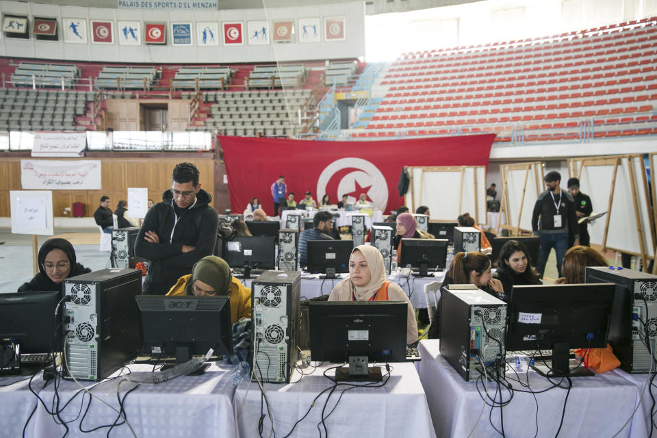 Members of the Independent Higher Authority for Elections count the votes one day after the parliamentary elections in Tunis, Tunisia, Sunday, Dec. 18, 2022. (AP Photo/Hassene Dridi)