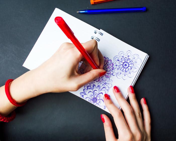 mujer pintando en un cuaderno con la mano izquierda