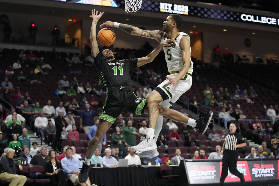 UAB's KJ Buffen (5) fouls Utah Valley's Tahj Small (11) during overtime of an NCAA college basketball game in the semifinals of the NIT, Tuesday, March 28, 2023, in Las Vegas. (AP Photo/John Locher)