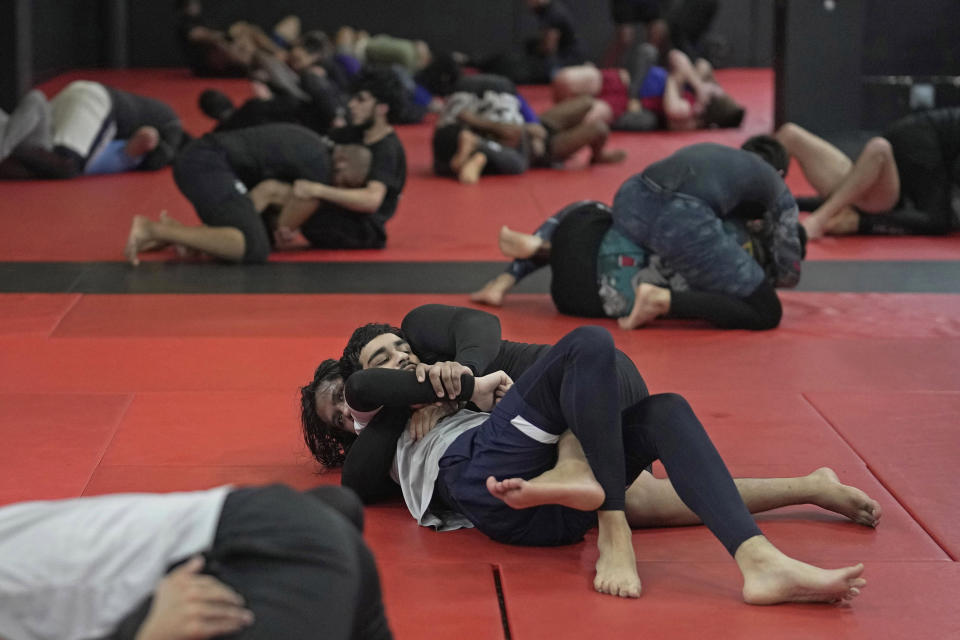 Students practice mixed martial arts moves at Diesel Gym in the Docklands area of East London, Monday, March 25, 2024. The special sessions run by the nonprofit SCK Fitness are held at 10 p.m. during the Muslim holy month of Ramadan to accommodate dawn-to-dusk fasting. (AP Photo/Kin Cheung)