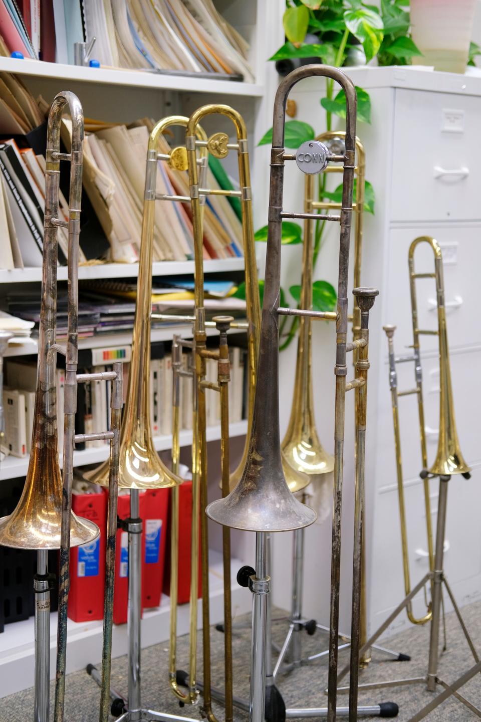 Several trombones are displayed in University of Oklahoma trombone professor Irvin Wagner's office inside OU's Catlett Music Center in Norman Tuesday, March 22, 2022.