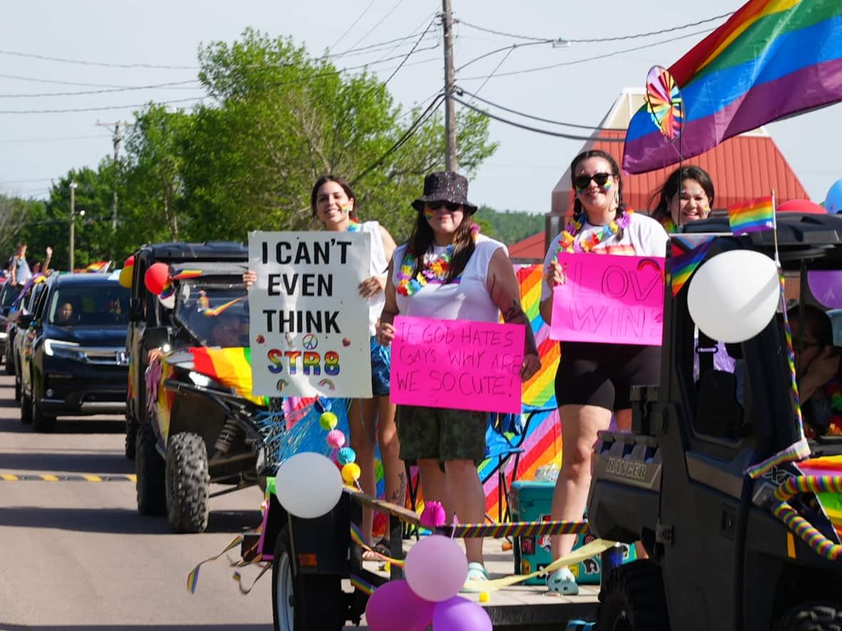 Patrice Dedam and Journey Levi (centre, with pink signs) take part in Elsipogtog's Pride parade Wednesday.  (Oscar Baker III/CBC - image credit)