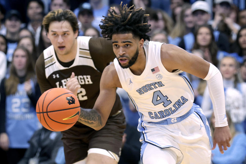 North Carolina guard RJ Davis (4) pushes the ball up the floor against Lehigh center JT Tan, left, during the first half of an NCAA college basketball game Sunday, Nov. 12, 2023, in Chapel Hill, N.C. (AP Photo/Chris Seward)