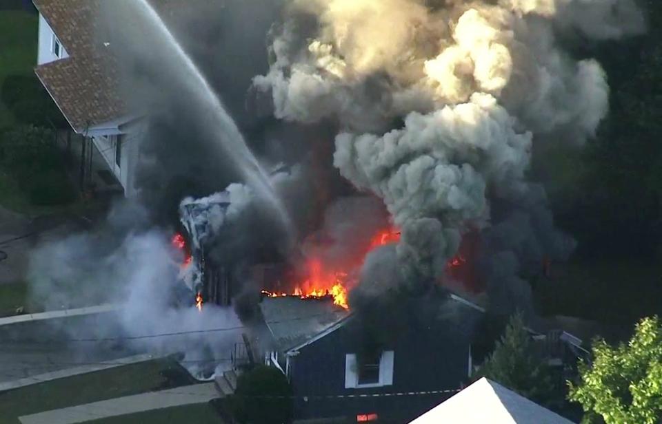 FILE - In this Sept. 13, 2018 file image from video provided by WCVB in Boston, flames consume the roof of a home following an explosion in Lawrence, Mass. The U.S. Attorney's office in Boston announced Wednesday, Feb. 26, 2020, that Columbia Gas Columbia agreed to plead guilty to violating the Pipeline Safety Act following an investigation into the catastrophic gas explosions. (WCVB via AP, File)