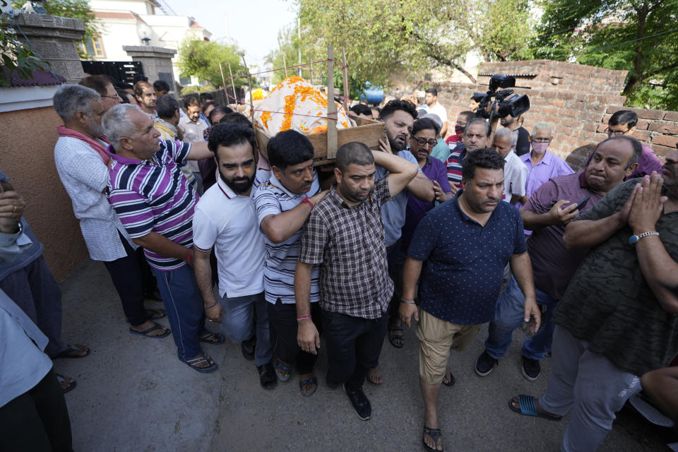 Relatives and friends carry the body of Rahul Bhat, a government employee killed on Thursday, for cremation in Jammu, India, Friday, May 13, 2022. Bhat, who was a minority Kashmiri Hindu known as "pandits," was killed by suspected rebels inside his office in Chadoora town in the Indian portion of Kashmir. (AP Photo/Channi Anand)