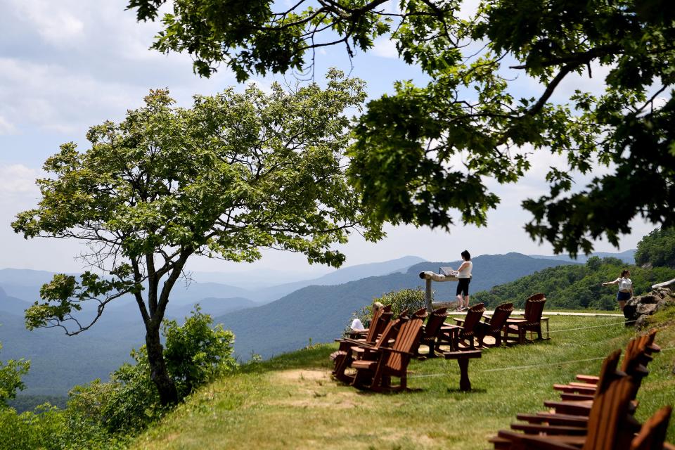 A woman reads the names of the mountains on a sign at the Pisgah Inn on the Blue Ridge Parkway on May 30, 2019. 