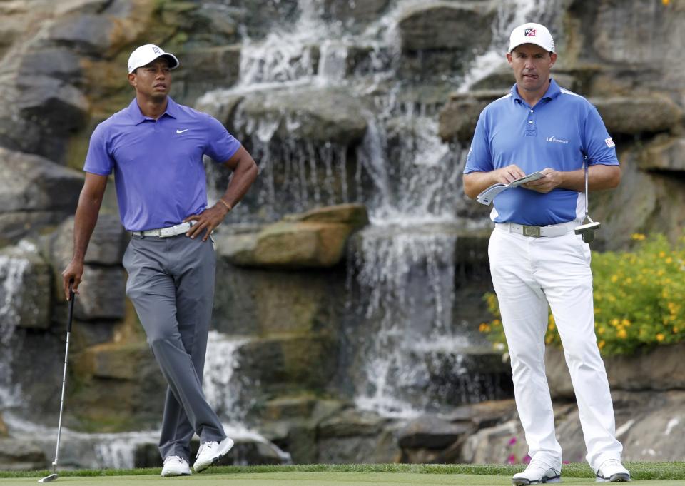 Tiger Woods (L) of the U.S. and Padraig Harrington of Ireland look on as they wait to putt on the 13th green during the first round of the PGA Championship at Valhalla Golf Club in Louisville, Kentucky, August 7, 2014. REUTERS/John Sommers II