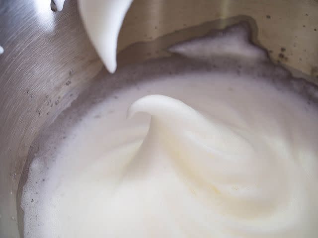 Egg whites beaten in a lightly greasy bowl formed soft peaks with no trouble, and with no noticeable delay compared to clean whites and equipment.