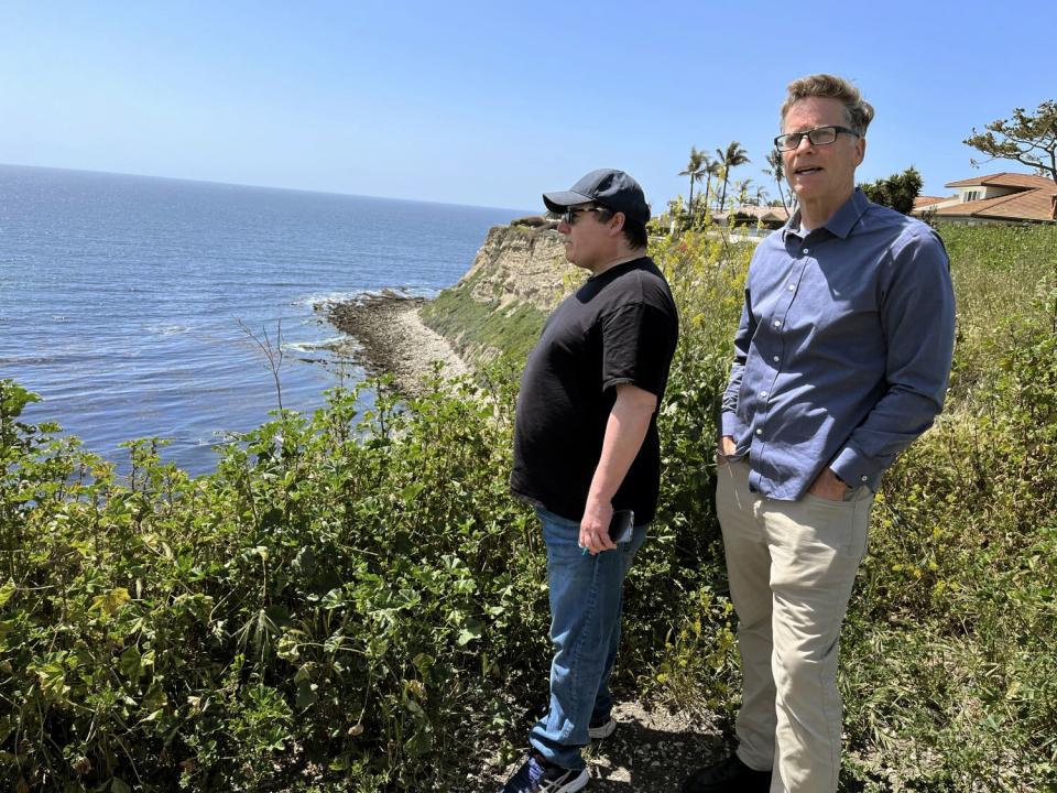 Two men overlook a bay