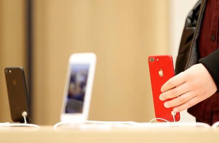 A person holds a red iPhone product at a Apple store in Nanjing, Jiangsu province, China, March 25, 2017. REUTERS/Stringer/Files