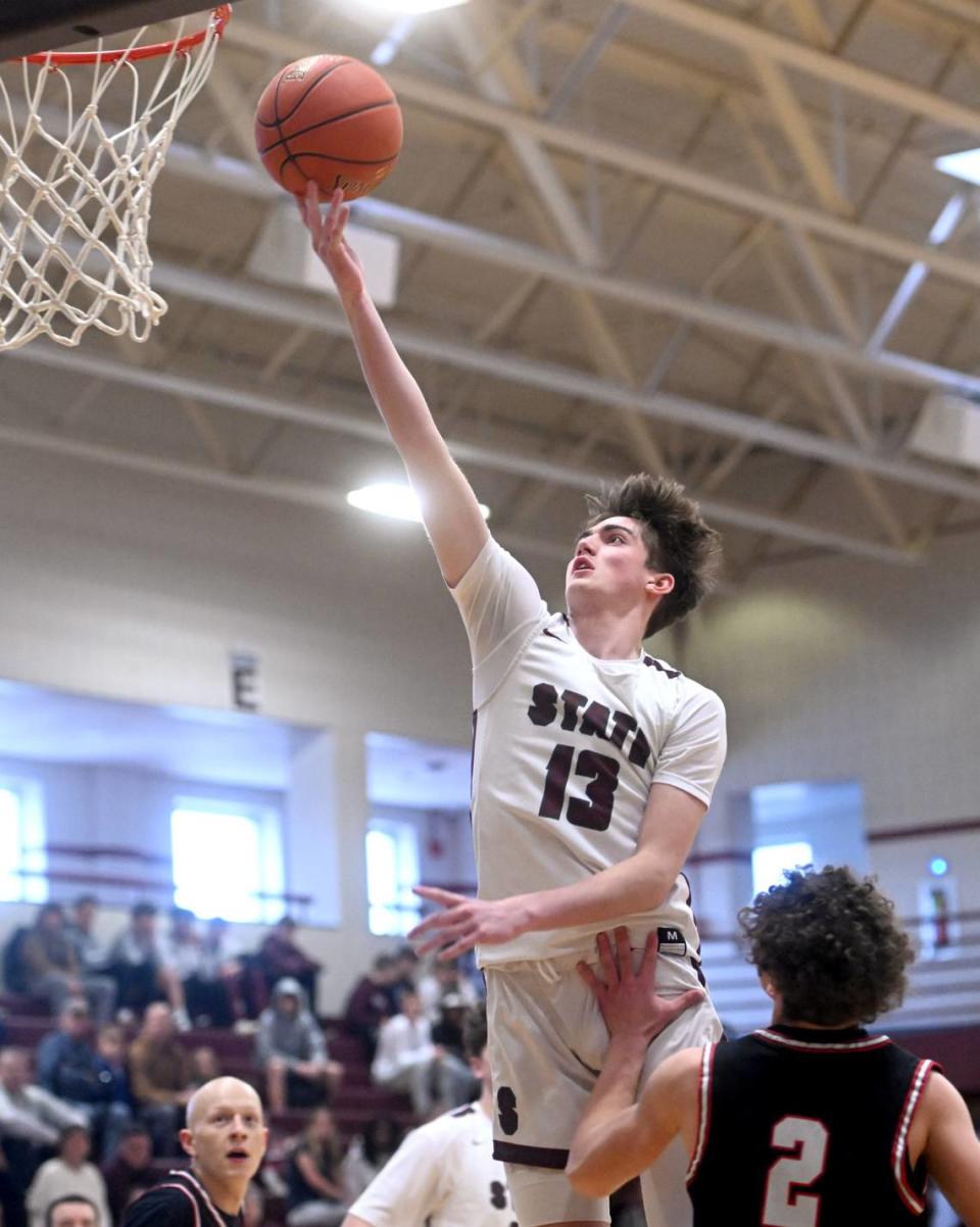 State College’s Ryan Perks goes in for a basket over an Upper St. Clair defender during the PIAA first round game on Saturday, March 11, 2023. State College won, 72-42.