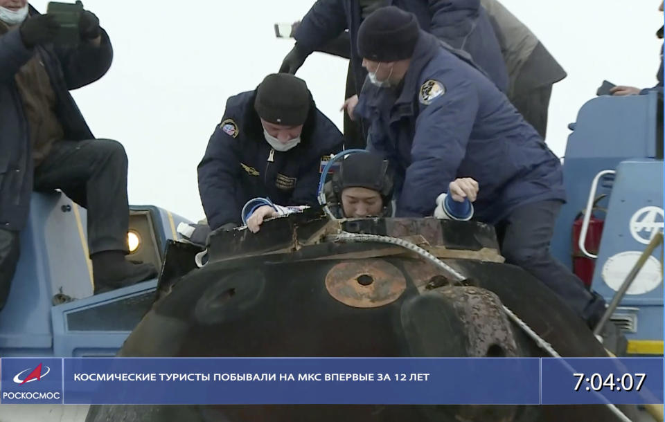 In this photo taken from video footage released by the Roscosmos Space Agency, Russian space agency rescue team help spaceflight participant Yusaku Maezawa to get from the capsule shortly after the landing of the Russian Soyuz MS-20 space capsule about 150 km ( 80 miles) south-east of the Kazakh town of Zhezkazgan, Kazakhstan, Monday, Dec. 20, 2021. The Japanese billionaire, his producer and a Russian cosmonaut safely returned to Earth on Monday after spending 12 days on the International Space Station. (Roscosmos Space Agency via AP)