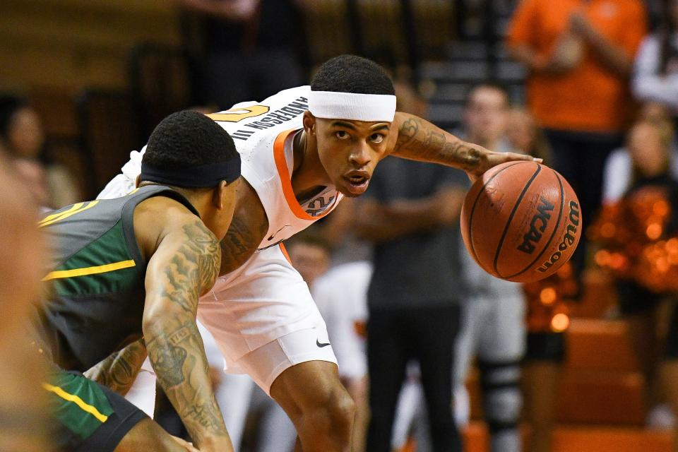 Oklahoma State guard Avery Anderson III, right, looks past Baylor defenders during the first half of a game on Feb. 21 in Stillwater.