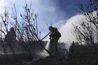 Firemen fight a fire on the slopes of Table Mountain, in Cape Town, South Africa, Monday, April 19, 2021. Residents were evacuated from Cape Town neighborhoods Monday as a huge fire spreading on the slopes of the city's famed Table Mountain was fanned by strong winds overnight and houses came under threat. (AP Photo)