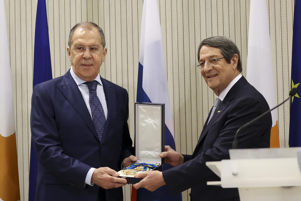 In this photo released by the Russian Foreign Ministry Press Service, Cypriot President Nicos Anastasiades, right, awards Russian Foreign Minister Sergey Lavrov with The Order of Makarios III after a joint news conference following their talks at the Presidential Palace in Nicosia, Cyprus, Tuesday, Sept. 8, 2020. (Russian Foreign Ministry Press Service via AP)